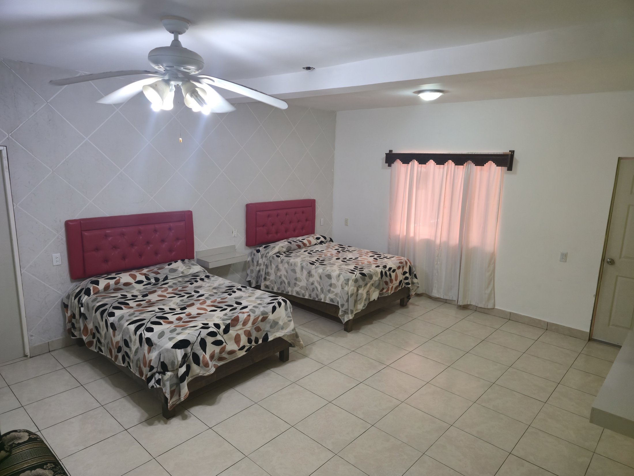 Vista amplia de una habitación 4 o 5 con dos camas y sofá