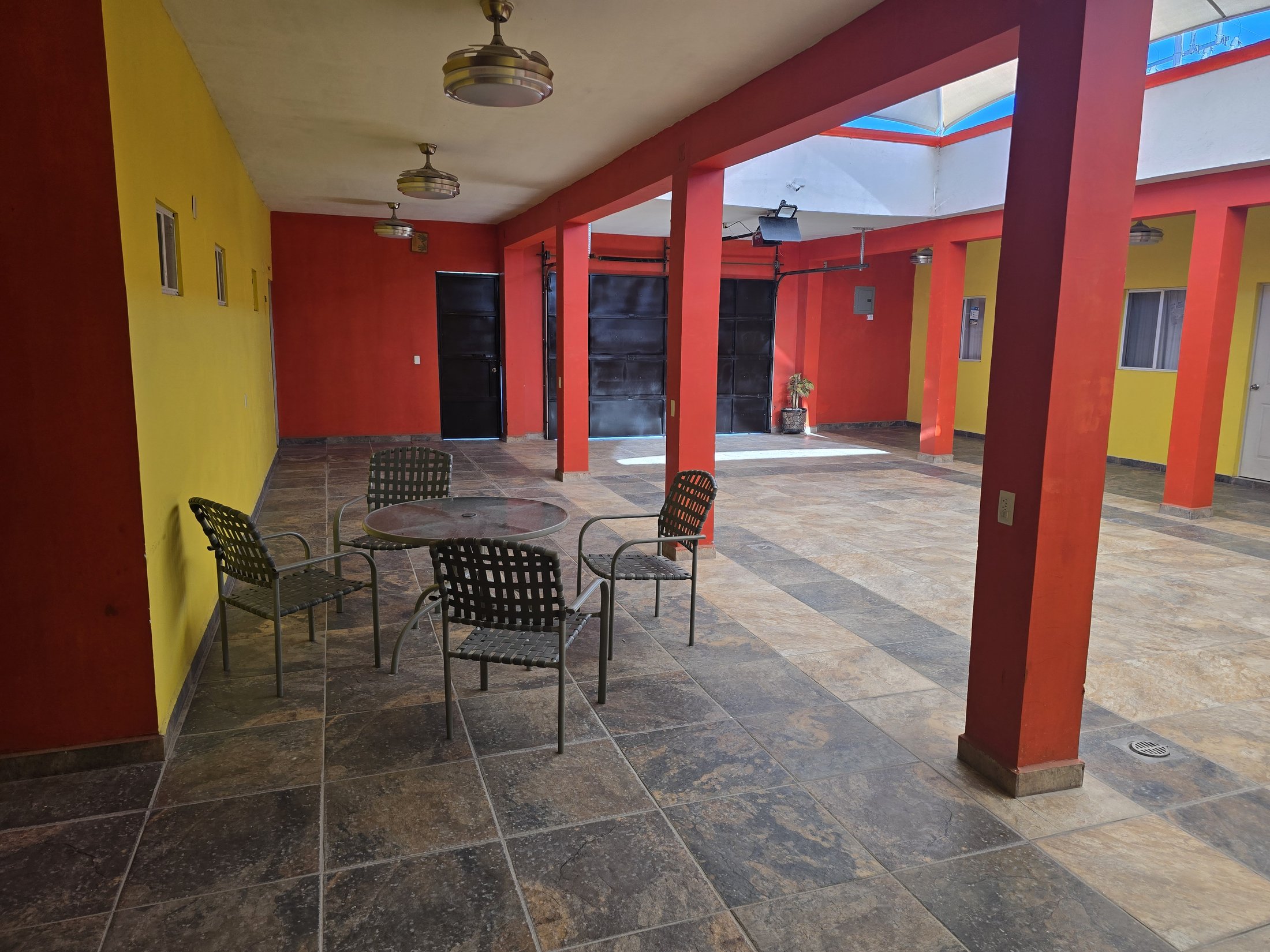 Mesa con sillas en el patio central de Hostal El Primo